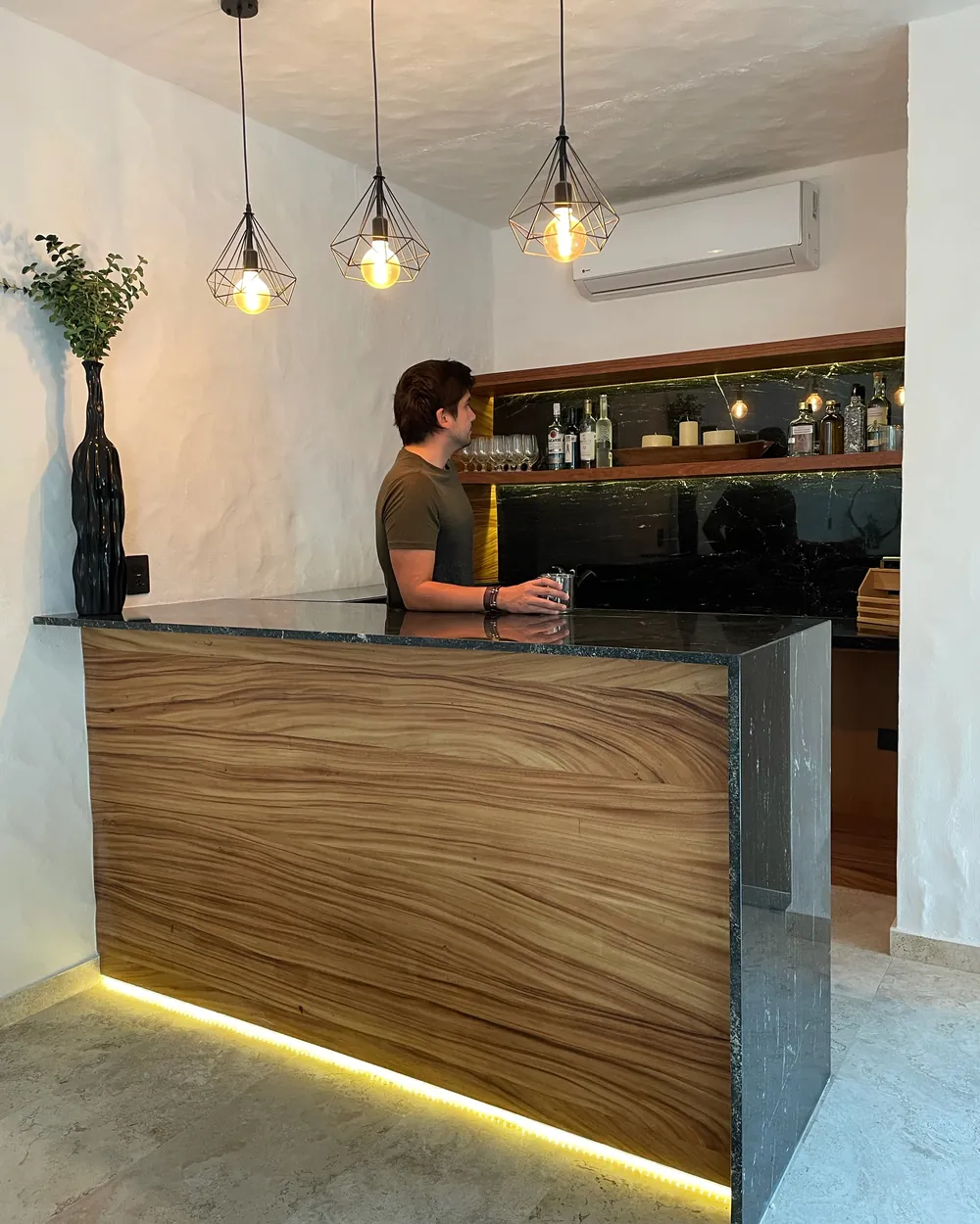 Barra sobre diseño en madera con cubierta de granito e iluminación inferior