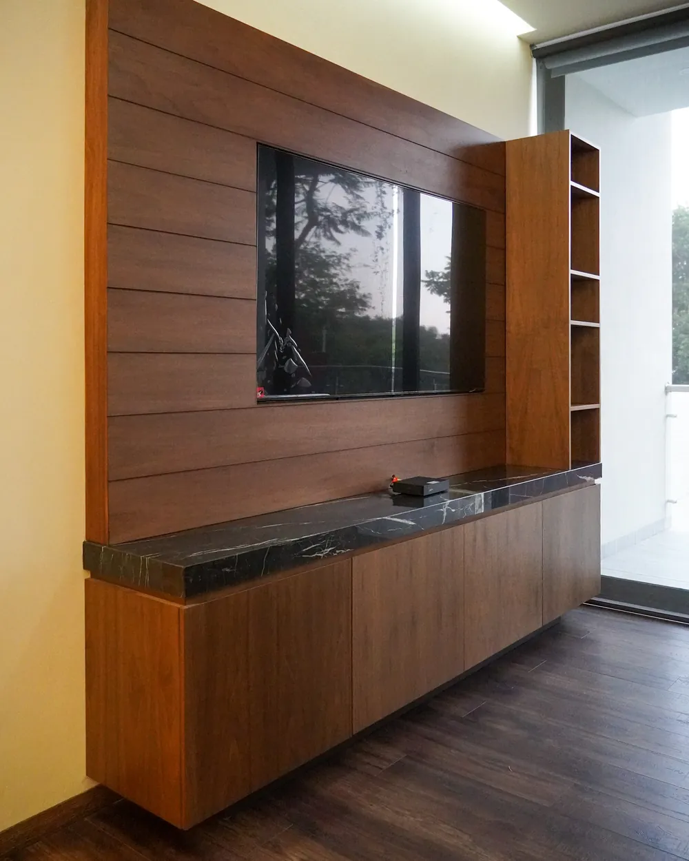 Muro de TV y credenza sobre diseño en madera con cubierta de mármol