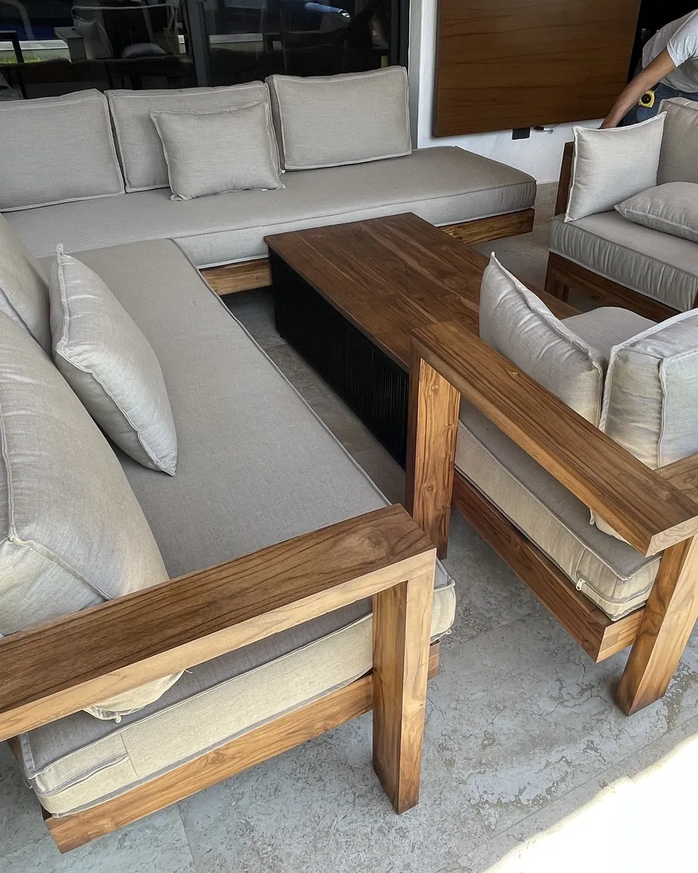 Sala de exterior sobre diseño en madera con cojines tapizados