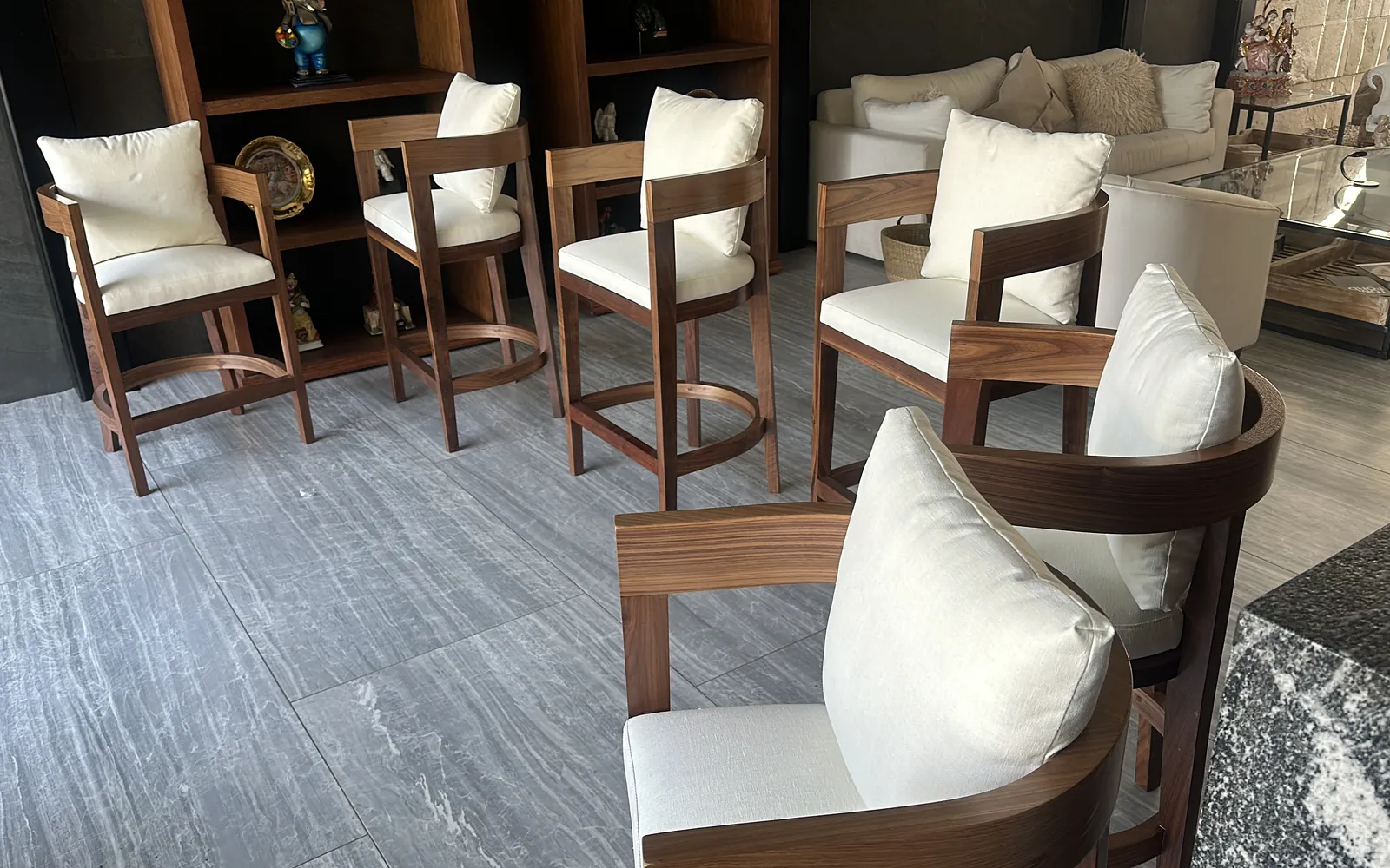 Sillas sobre diseño en madera con cojines claros en una sala