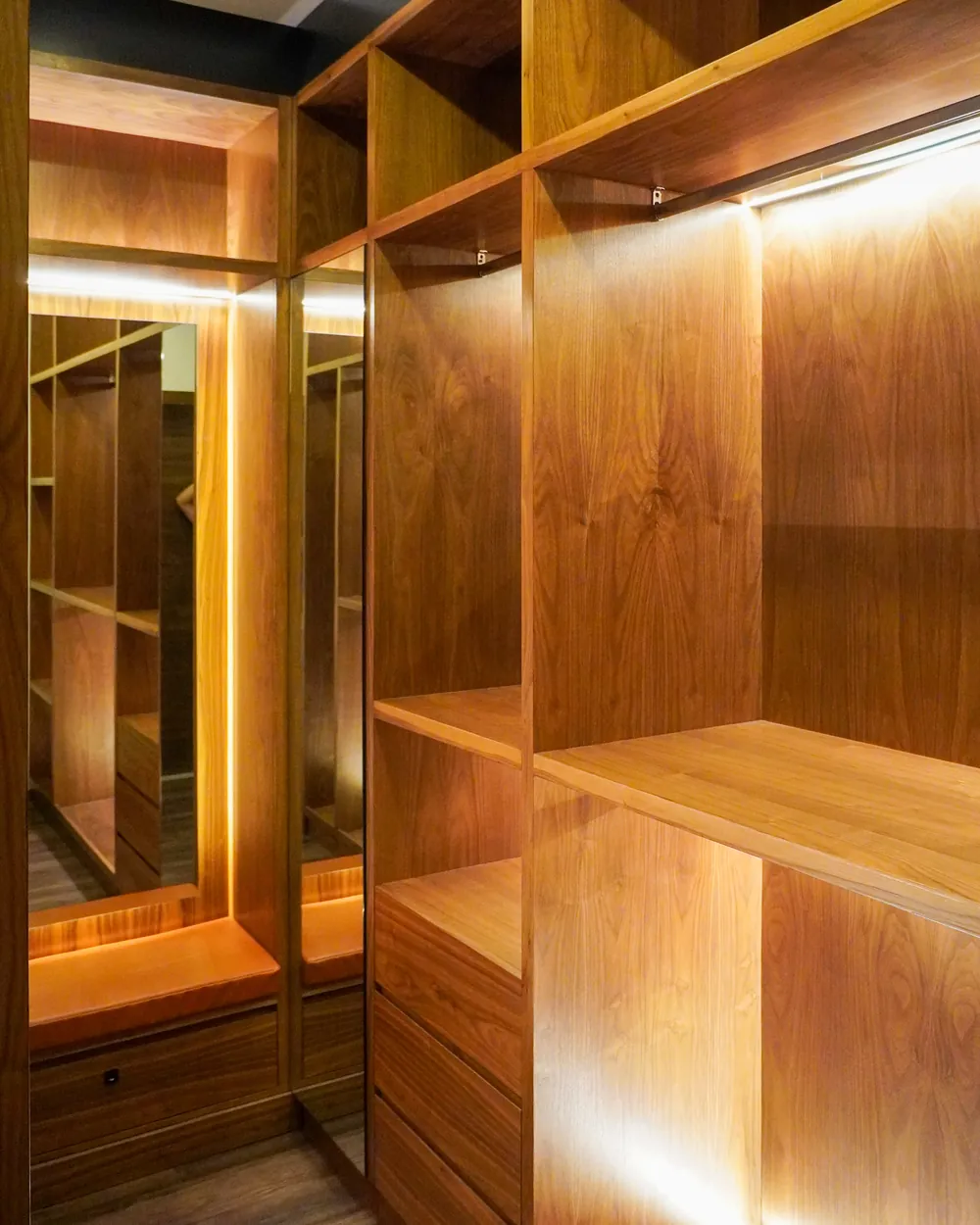 Vestidor walk-in closet sobre diseño en madera con iluminación integrada